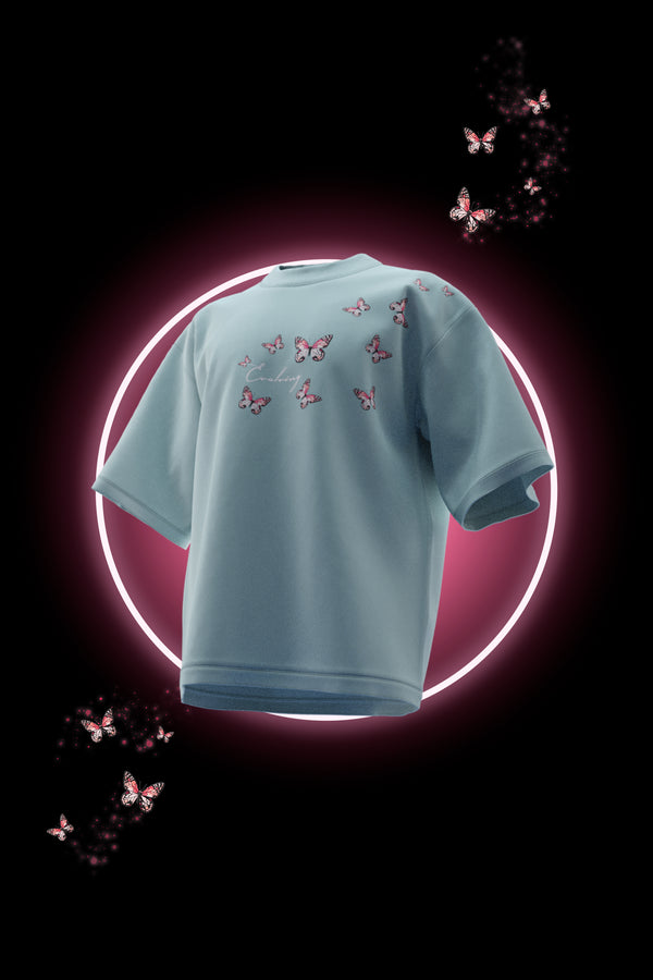 Light blue t-shirt with butterfly patterns on a black background with butterfly graphics.