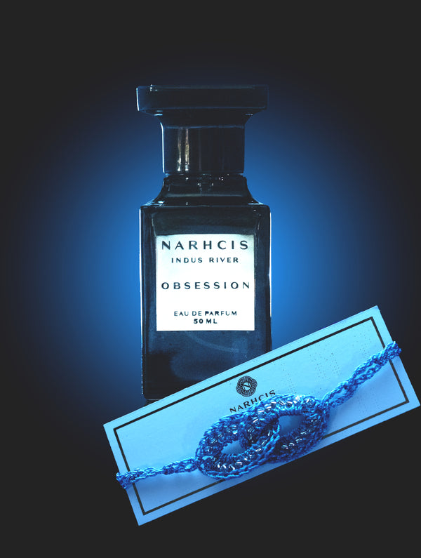 Perfume bottle labeled 'Narhcis Indus River Obsession' with a blue glow on a dark background
